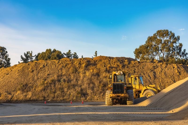 Wheel loader beside a large stockpile of dirt